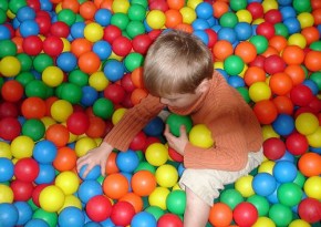 Child playing with plastic balls - Julie Kertesz